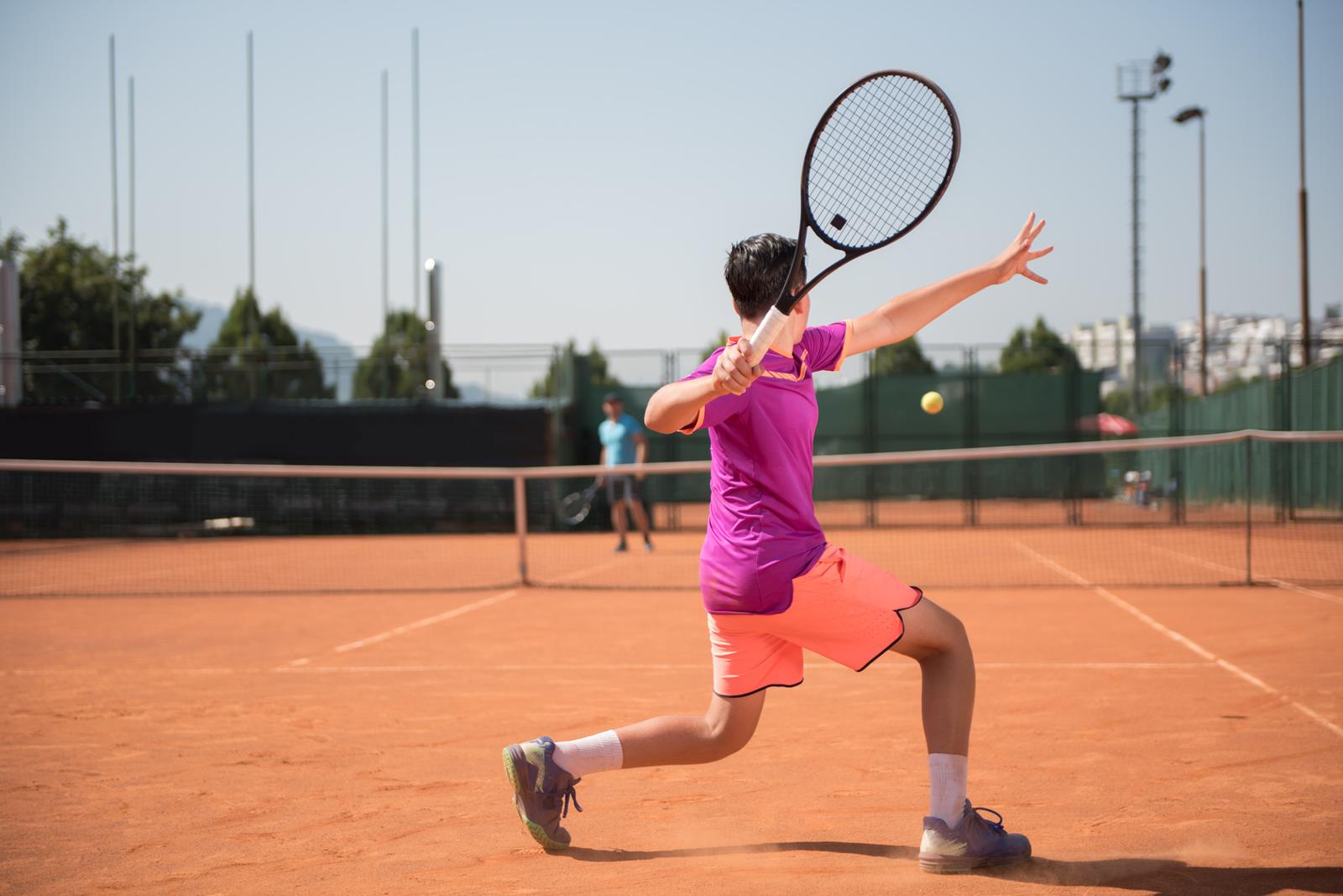 Young tennis player hitting a forehand